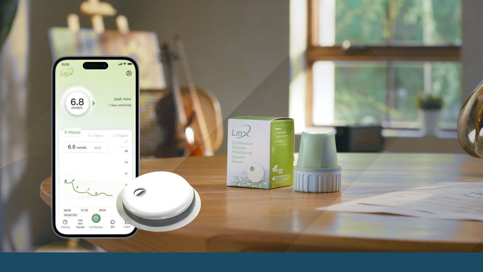 The LinX app showing a real-time glucose reading and trend graph, next to the sensor and its box